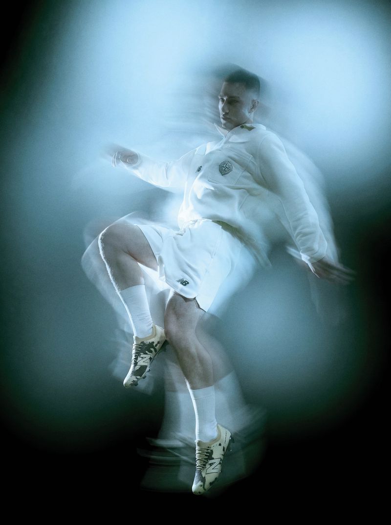Man captured mid-air in a white sportswear kit with motion blur against a dark background.