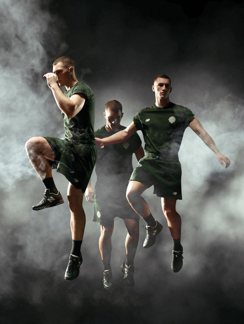 Three athletic men in matching green t-shirts and shorts jumping mid-air surrounded by smoke against a dark studio backdrop.