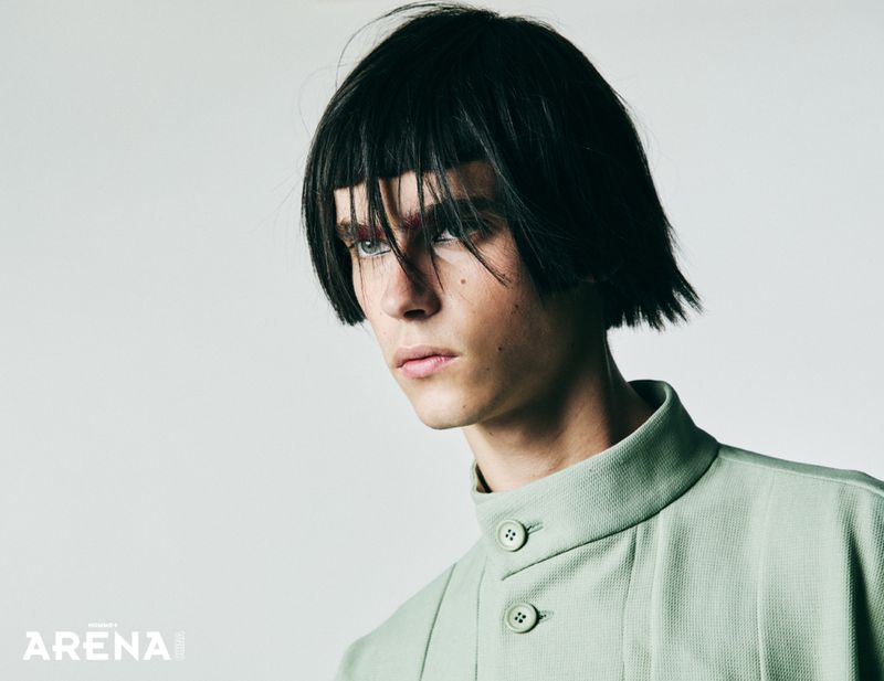 Model Frederic Bittner with a dark blunt bob and high-collar pale green shirt against a light studio backdrop.