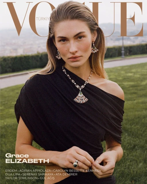 Grace Elizabeth wearing an off-the-shoulder black dress and statement jewelry for the Vogue Turkey cover in an outdoor park setting.