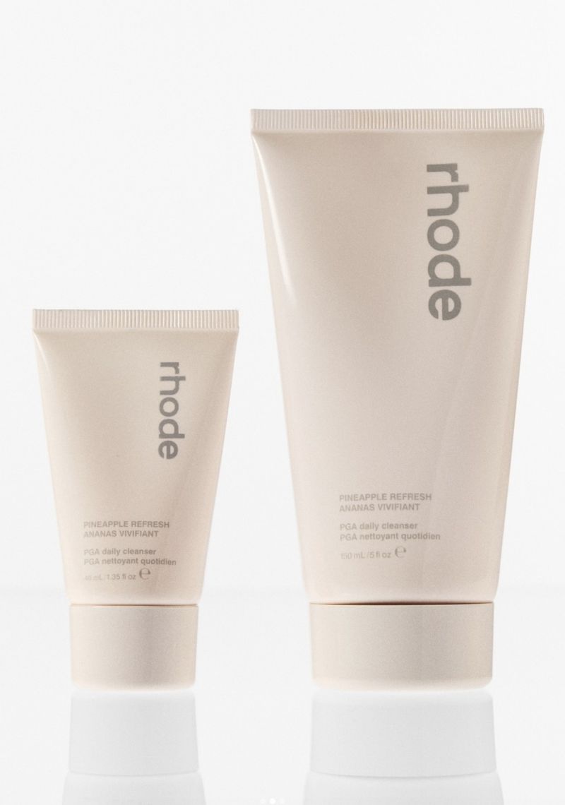 Two 'rhode' brand face cleanser tubes in a studio setting, showcasing skincare products against a bright, neutral background.