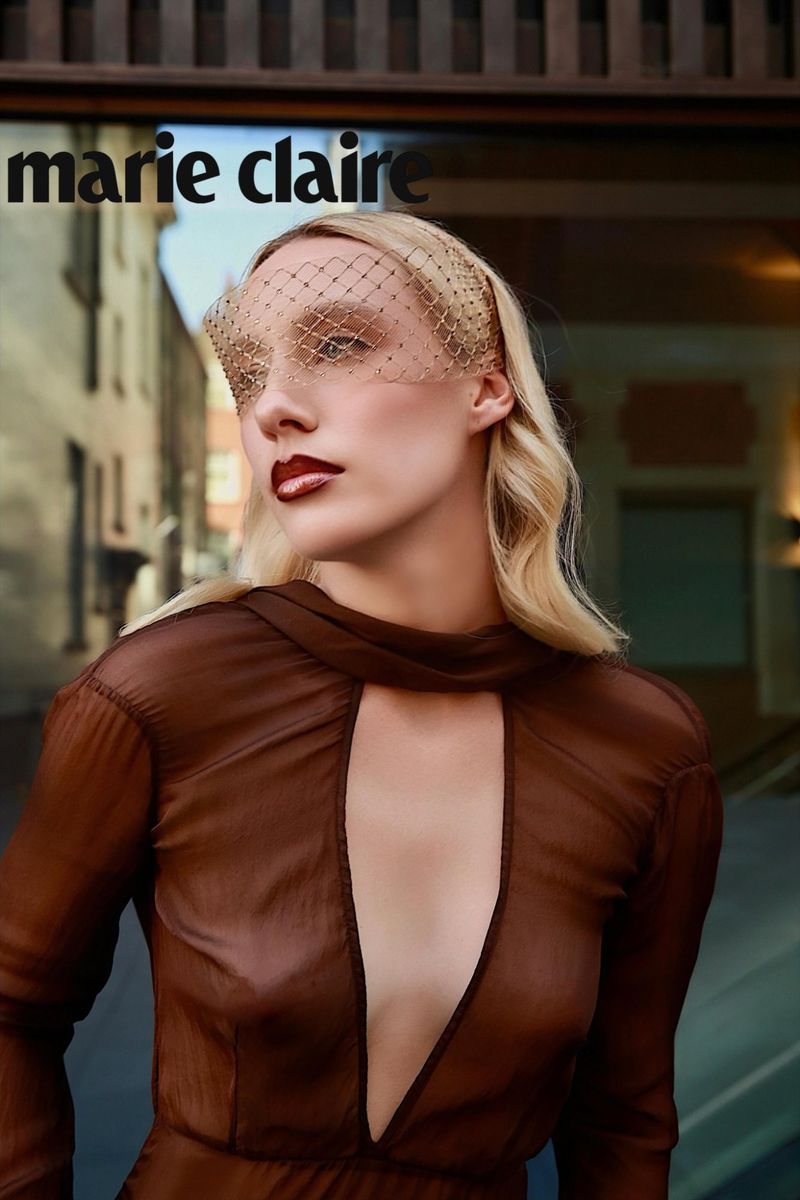 Blonde woman in a sheer brown dress with a birdcage face veil posing for a Marie Claire Serbia fashion editorial.
