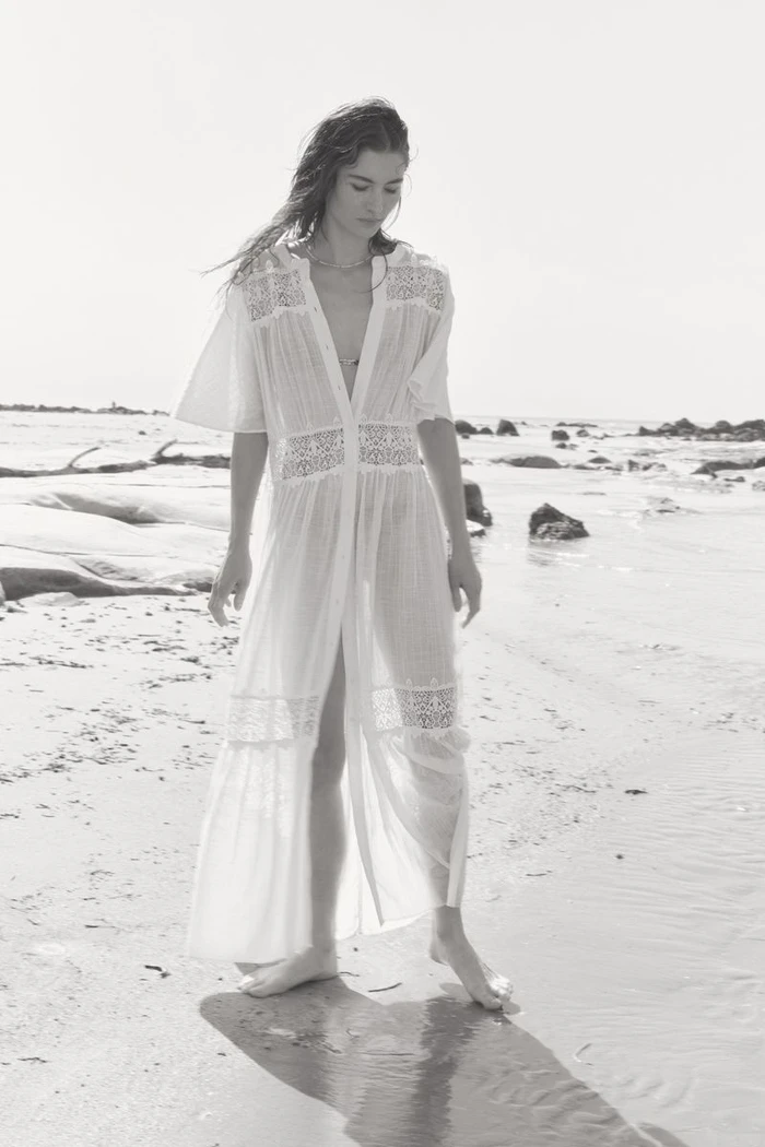 Grace Elizabeth wearing a white lace dress on a sandy beach for H&M shot by Olivia Frølich