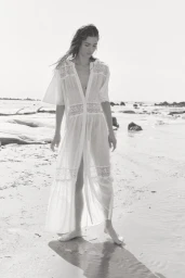 Grace Elizabeth wearing a white lace dress on a sandy beach for H&M shot by Olivia Frølich