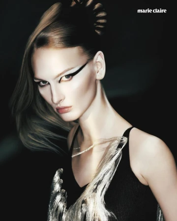 Model Astrid Baauer with dramatic graphic eyeliner and an avant-garde hairstyle against a dark studio background.