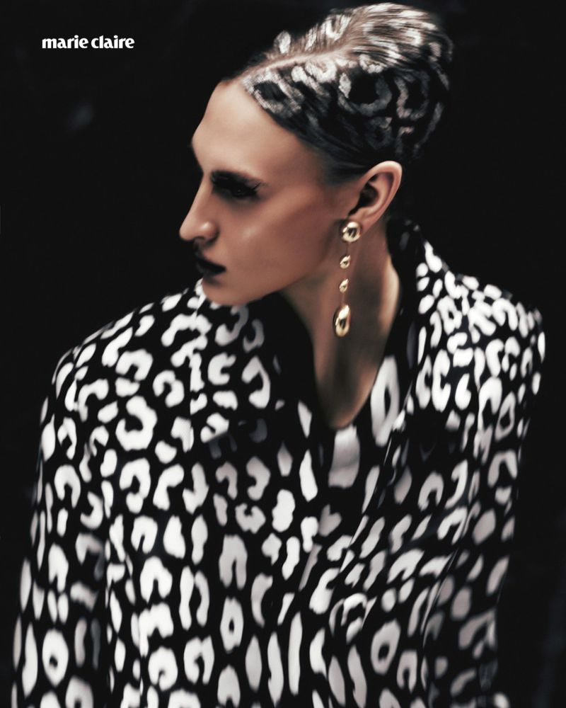 Model Astrid Baauer wearing a black and white leopard print jacket with matching patterned hair and a gold drop earring.