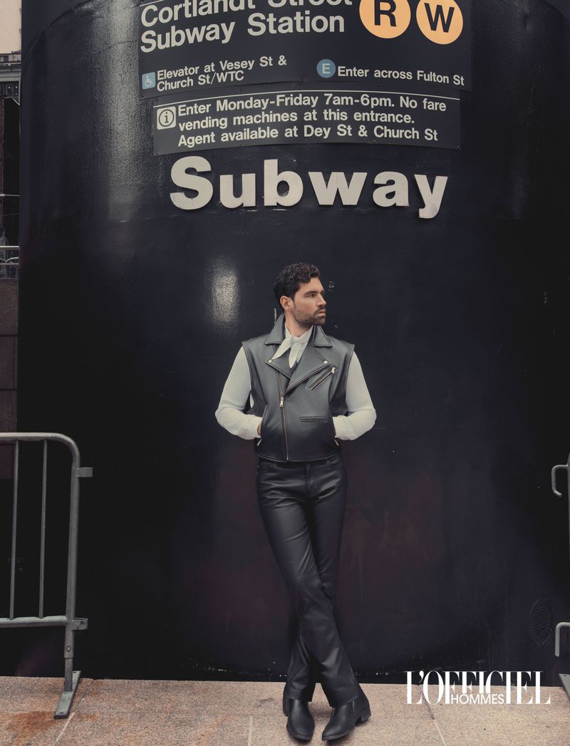 Model Emanuele Antonio Panico in a black leather vest and pants standing outside the Cortlandt Street Subway Station entrance.