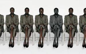 Model Alek Wek seated in repeated poses wearing a grey tailored suit and black flats across white chairs against a white background.