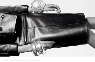 Model Yuliana Perez in a black leather jacket, pencil skirt, and chunky sculptural bangles against a clean white backdrop.