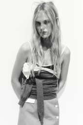 Model Rikke Nora Palsgaard Ronne posing in a layered knit top against a plain white studio background in black and white.