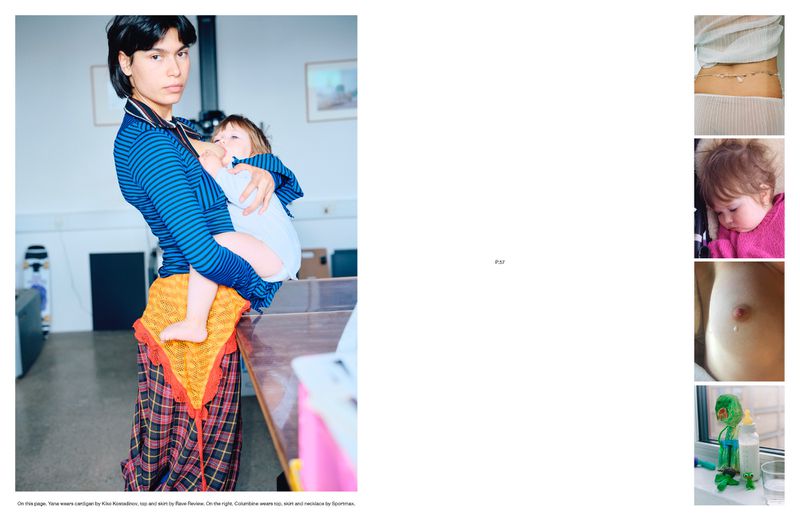 Image of an adult holding a baby indoors. The adult wears a blue striped shirt and a patterned skirt. The baby is swaddled in white.