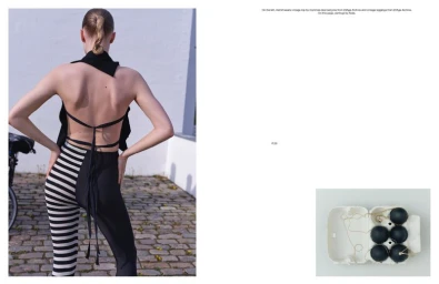 Model seen from behind wearing a black backless top and patterned leggings on a cobblestone surface