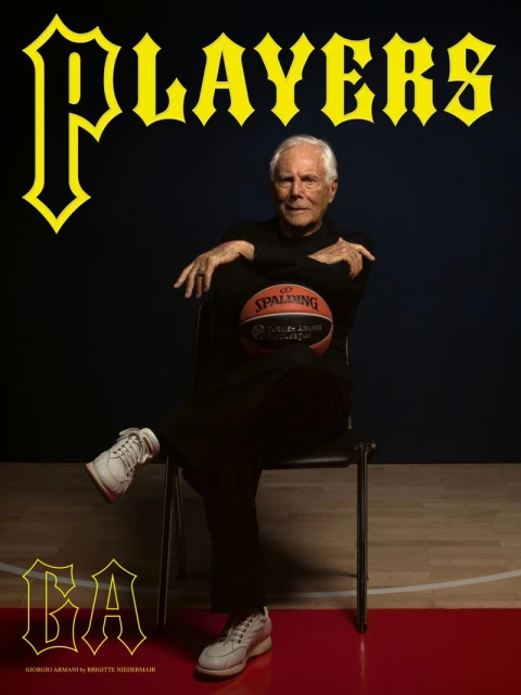 Giorgio Armani sitting in a chair, holding a basketball, wearing black clothing, and white sneakers, with the word 'Players' above him.