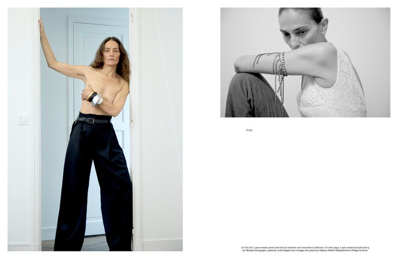 A topless adult female with bare feet stands in a doorway wearing black pants, with jewelry, contrasted by a black and white portrait.