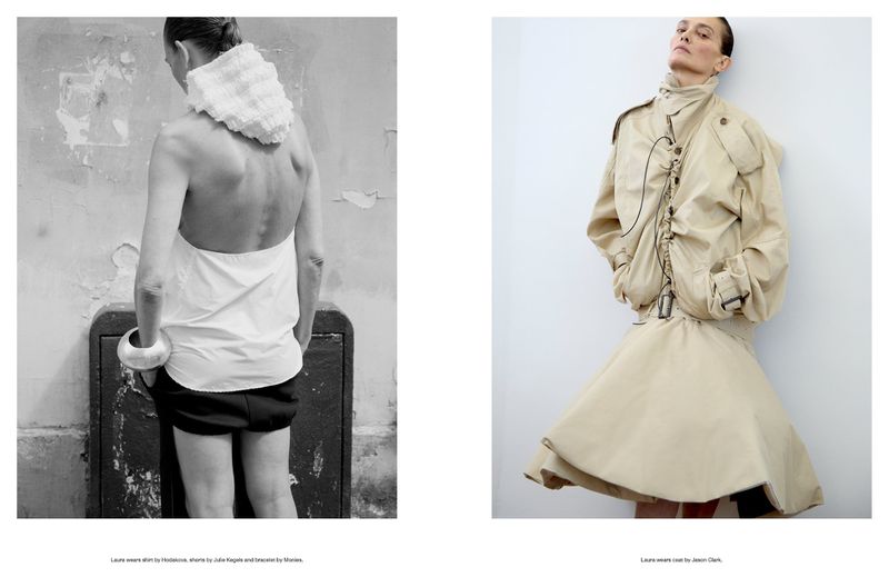 Editorial fashion shot featuring two women, one in a white top and black shorts against a textured wall, the other in a beige jacket and skirt.