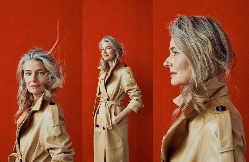 Three-panel portrait of a mature woman with silver hair wearing a trench coat, set against a vibrant red backdrop.