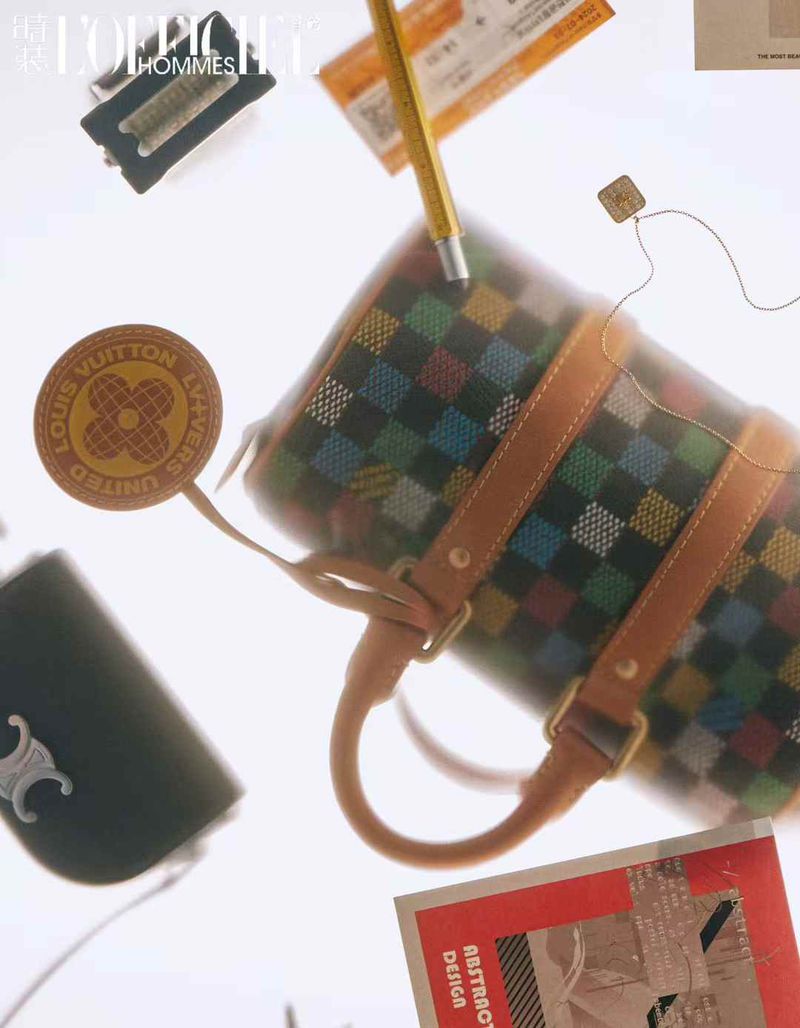 Overhead shot of a barrel bag featuring a colorful checkered pattern, complemented by a leather logo tag and other fashion accessories.