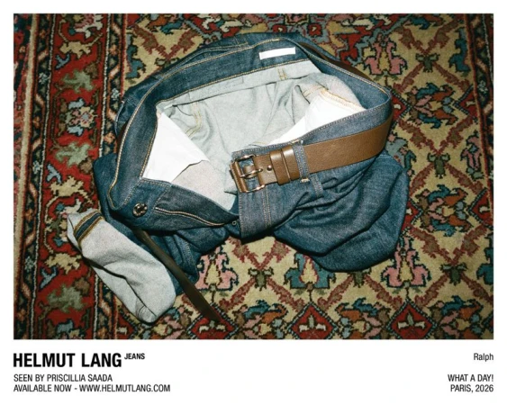 Helmut Lang denim jeans with a brown leather belt laid crumpled across an ornate patterned oriental rug.