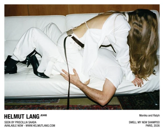 A woman in a white backless top and white jeans straddles a man lying face down on a white leather couch.
