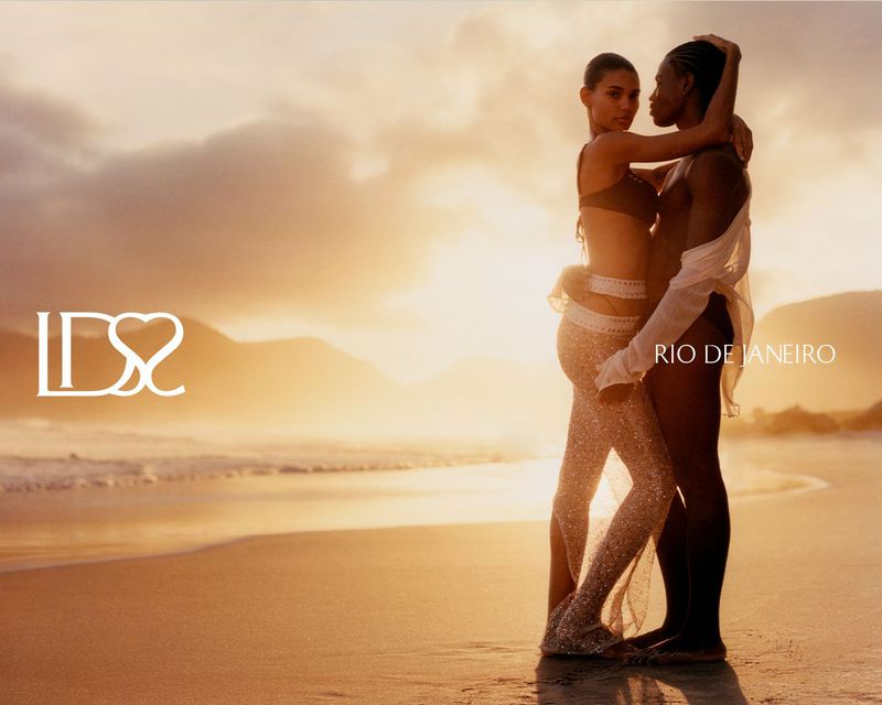 Two models embracing intimately on a sandy beach at sunset during the Ludovic de Saint Sernin swim 2026 campaign.