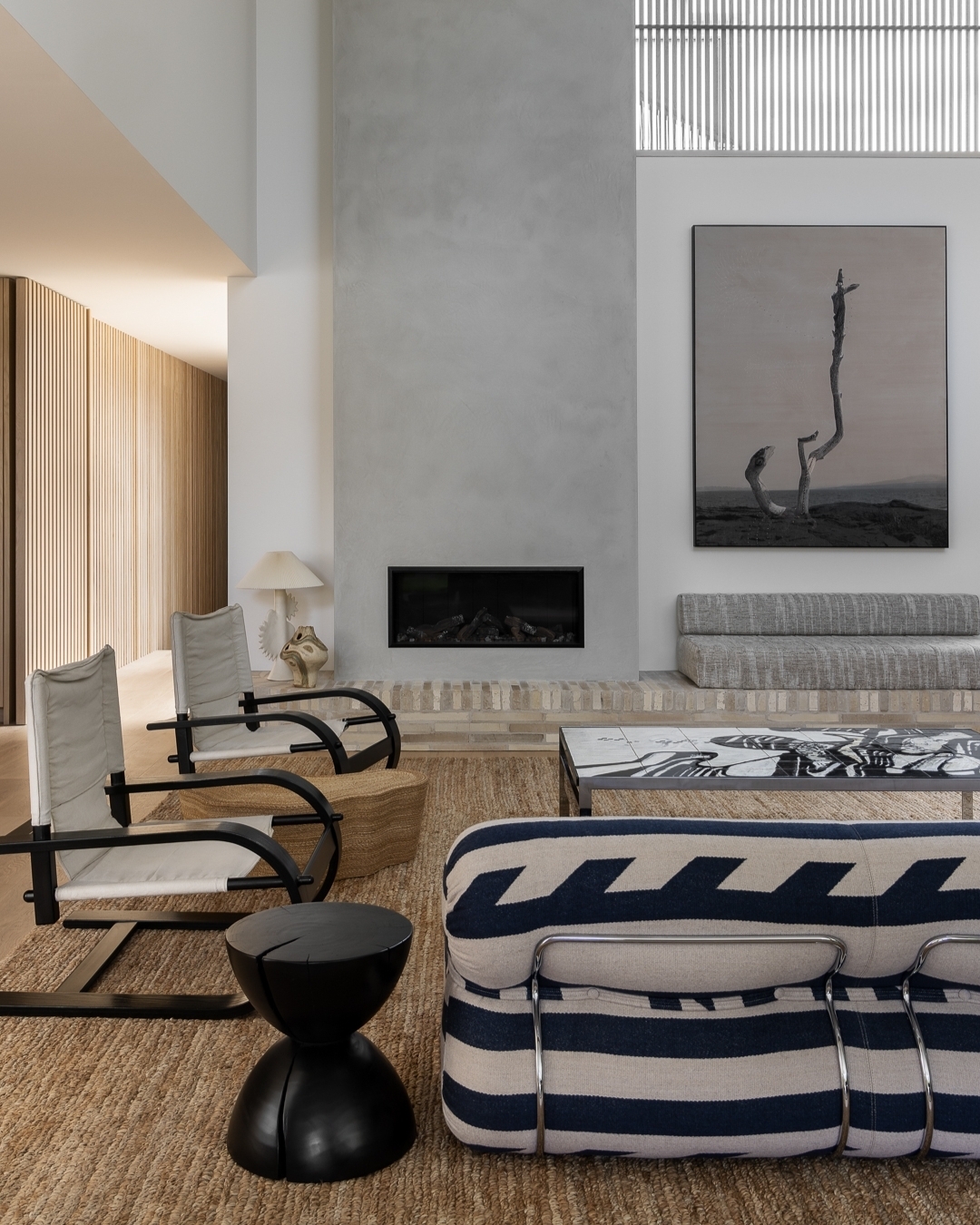 Living room interior with modern furniture, including armchairs, sofas, and a coffee table, in a neutral color palette and minimalist design.