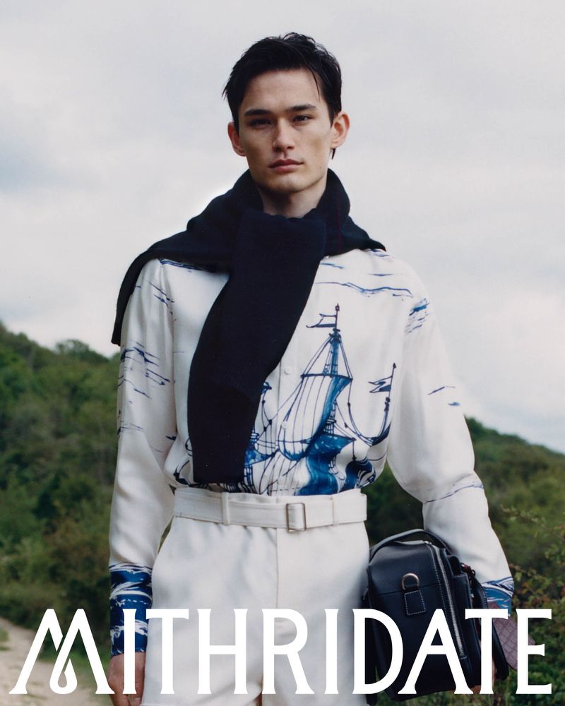 Model wearing a printed shirt and dark sweater outdoors with hills in the background for Mithridate Pre Fall 26 campaign