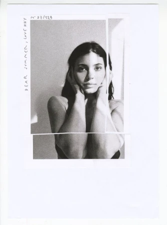 Black and white portrait collage of Kylie Jenner resting her hands against her face with handwritten text on the paper border.
