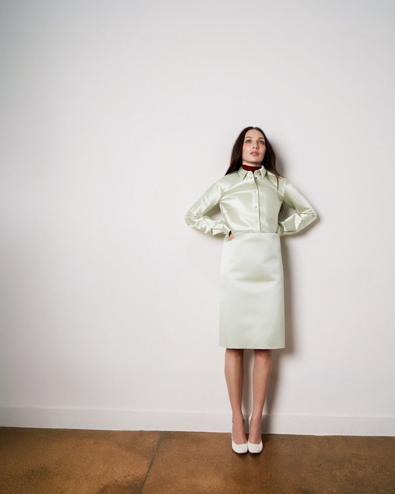 Maddie Ziegler wearing a satin light green matching set against a plain wall for French Fries Magazine editorial
