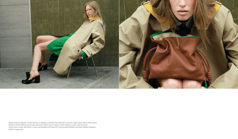 Model Leanne De Haan in a beige trench coat and green dress holding a brown leather drawstring clutch bag.