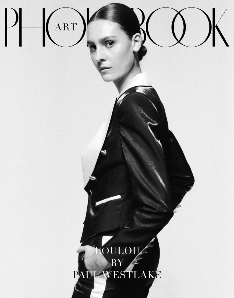 Black and white magazine cover featuring a model with sleek hair wearing a structured tailored blazer against a white backdrop.