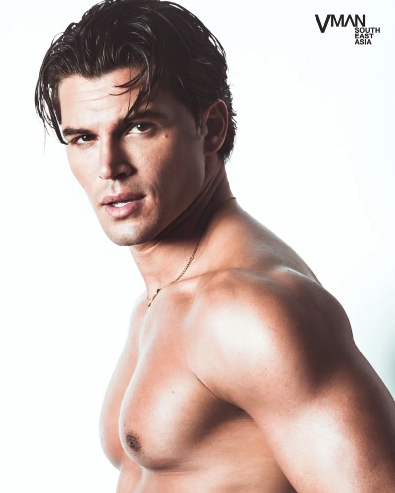 Antonio Medugno posing shirtless against a white background for a VMAN South East Asia editorial portrait.