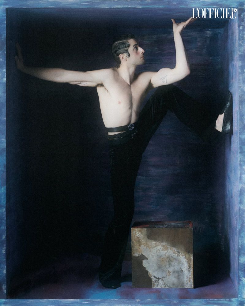 Shirtless man with styled hair posing inside a dark blue enclosed studio set box with a textured block for L'Officiel Chile editorial