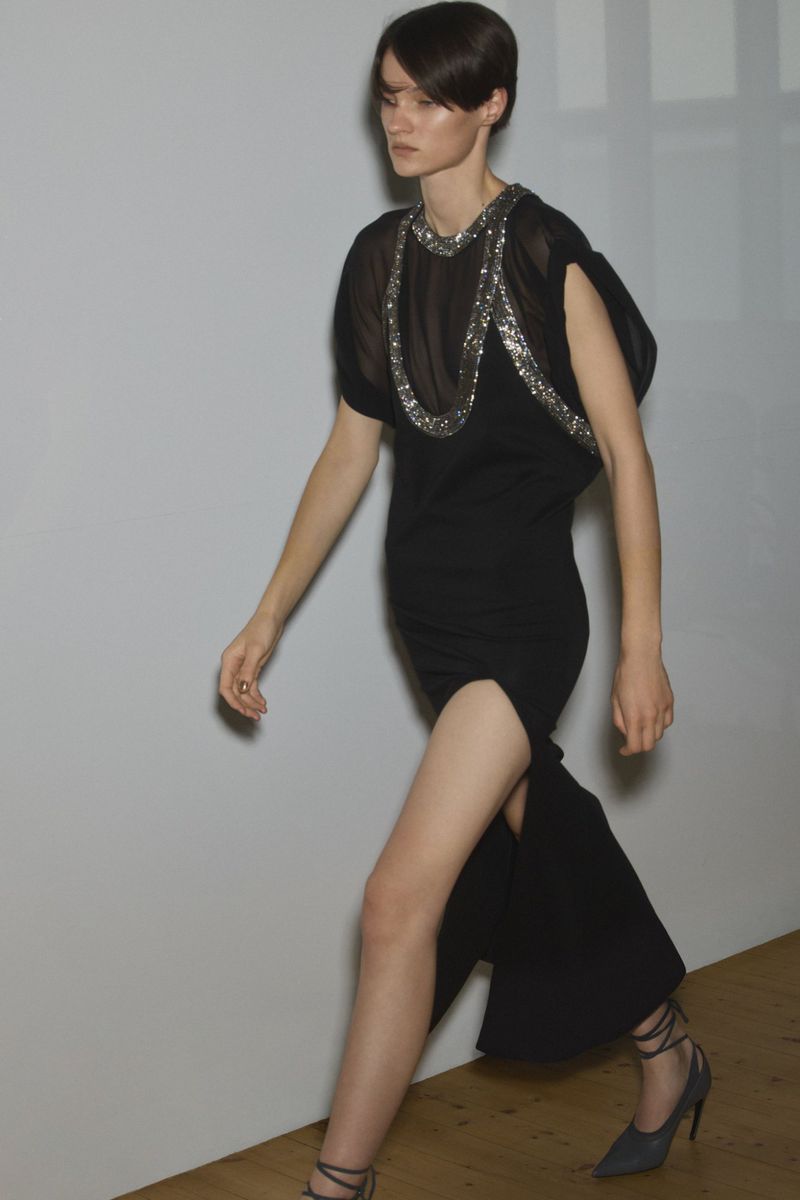 Model Tanya Churbanova walking in a black slit dress with silver embellishments for The Attico F/W 26 Lookbook.