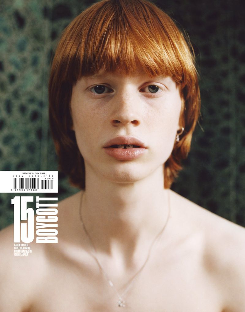Magazine cover features a young, fair-skinned model with ginger hair, gazing directly at the viewer, wearing a silver necklace indoors.