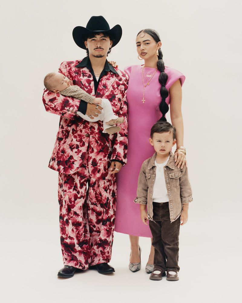 Family portrait for American Vogue project Coming Home featuring man in floral suit with baby, woman in pink dress, and young boy.