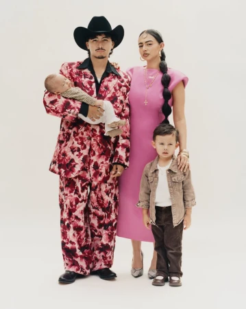 Family portrait for American Vogue project Coming Home featuring man in floral suit with baby, woman in pink dress, and young boy.