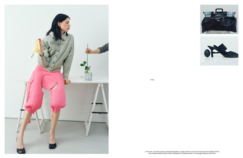 Editorial fashion shot of a woman in pink pants holding a banana peel, with a rose, handbag, and heeled shoe on display.