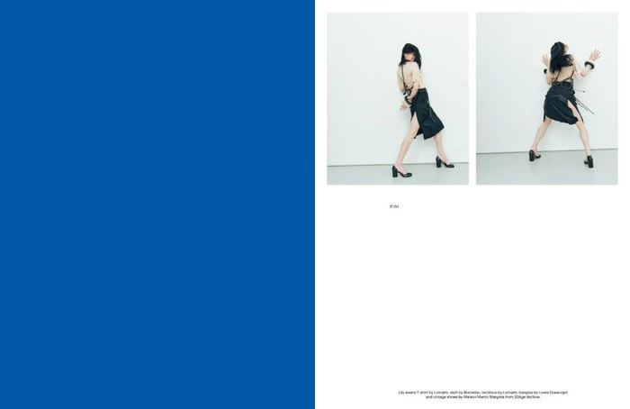 Magazine editorial spread featuring model Lily McMenamy posing in a beige top and black skirt beside a solid blue page.