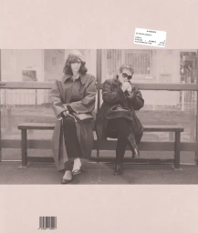 Two women wearing dark coats seated together on a bus stop bench for Albion Magazine Issue 2 cover.