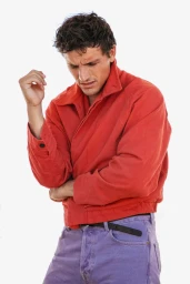 Model Sergio Modrego wearing a red jacket and lavender trousers against a seamless white background.