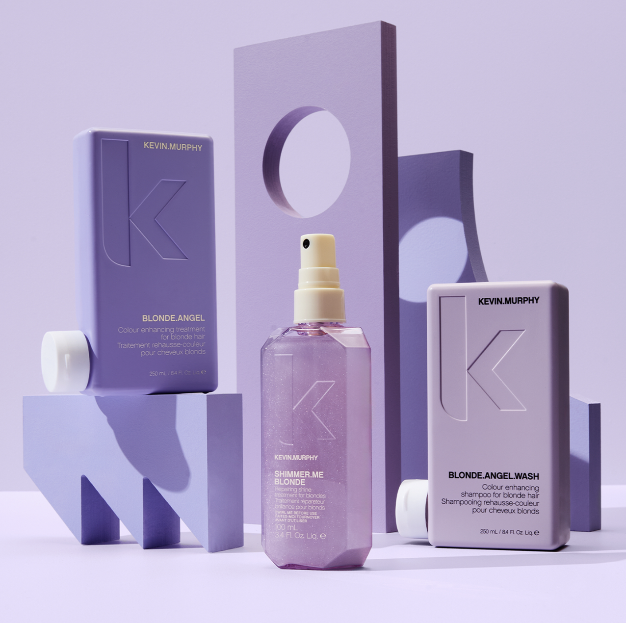 Kevin Murphy Blonde Angel and Shimmer Me Blonde hair care products displayed against a lavender backdrop with geometric shapes, studio lighting.