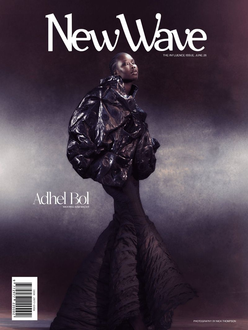Model Adhel Bol wearing a voluminous glossy black jacket and flared maxi skirt on the cover of New Wave Magazine.