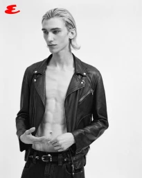 Model Noah Hanes posing shirtless in an open black leather biker jacket and dark denim against a white studio background.