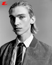 Portrait of a male model wearing a striped shirt, tie, and jacket against a plain grey backdrop for Esquire Thailand.