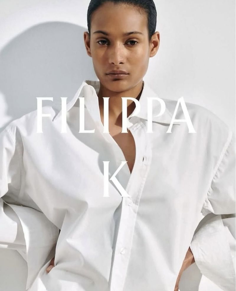 Portrait of an adult woman wearing a white button-down shirt, set against a bright white backdrop with the text FILIPPA K superimposed.