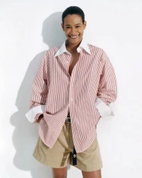 Model Mar G smiling in an oversized red and white striped shirt and khaki shorts against a white studio background.
