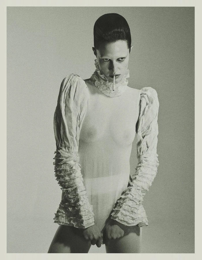 Model Julia Banas in a white ruffled top holding a cigarette for Tidal Magazine, photographed by Edyta Chachulska