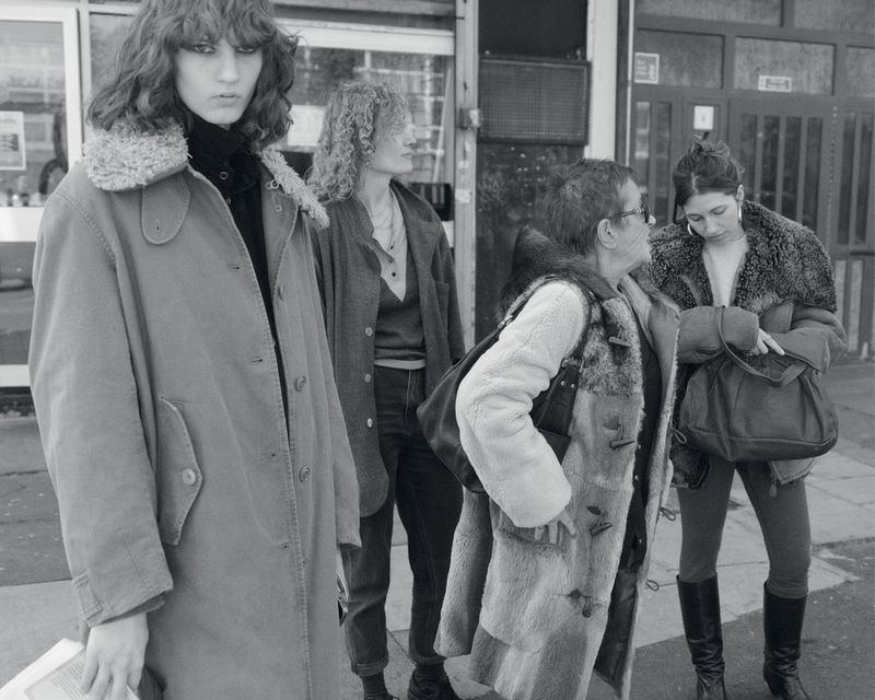 Black and white fashion editorial featuring four women in coats standing outside a building for Albion Magazine
