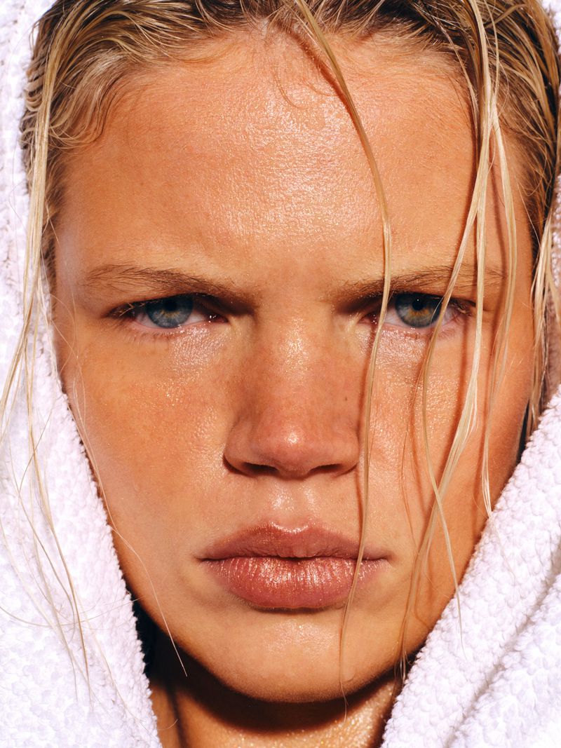 Extreme close-up portrait of model Luca Biggs with wet blonde hair wrapped in a white terrycloth towel.