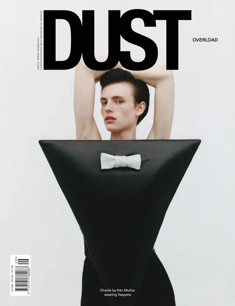 Model Charlie Jones on a magazine cover wearing a black inverted triangle garment with a white bow tie against a white background.